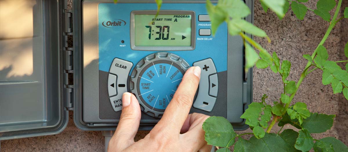 Close up of hand adjusting a irrigation clock