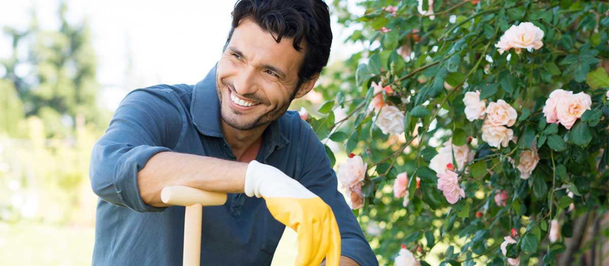 Man smiling, holding shovel