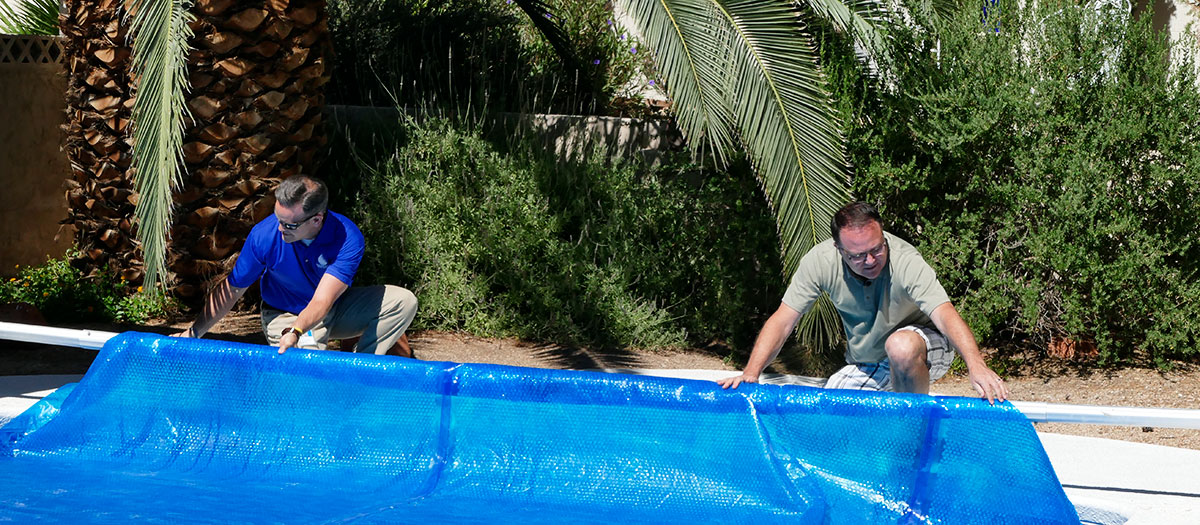 People putting cover on pool