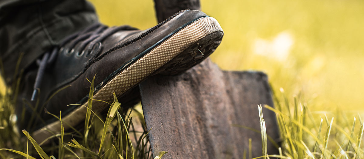 Foot pushing shovel into grass