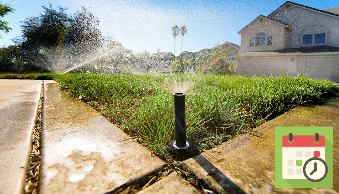 Low shot of grass in front of house with sprinklers running