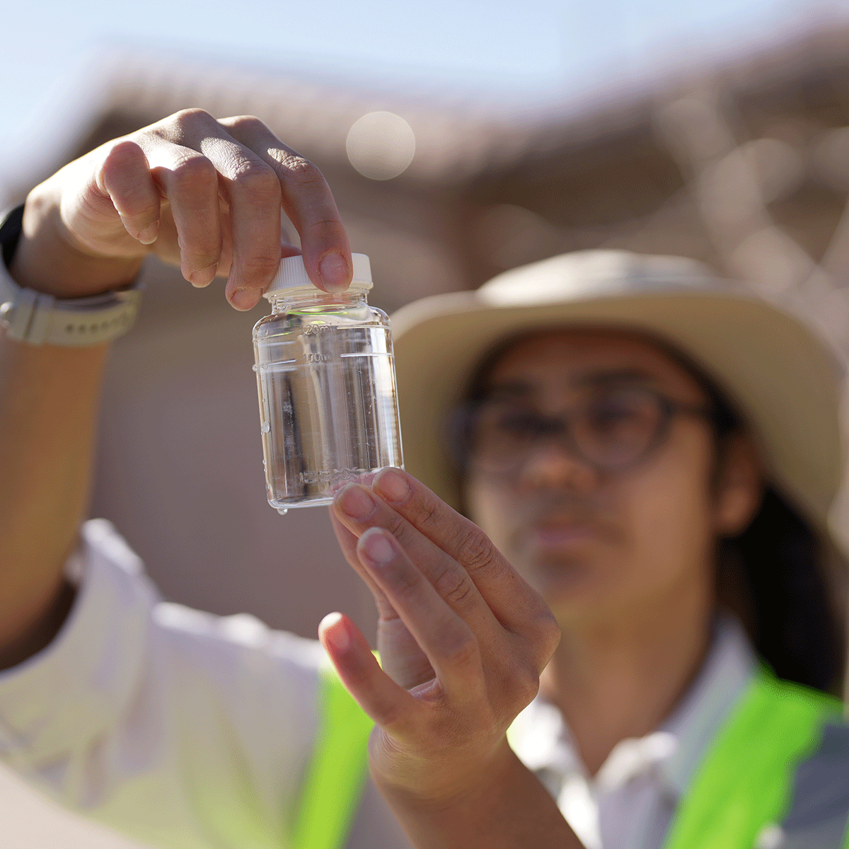 Field worker holding water sample