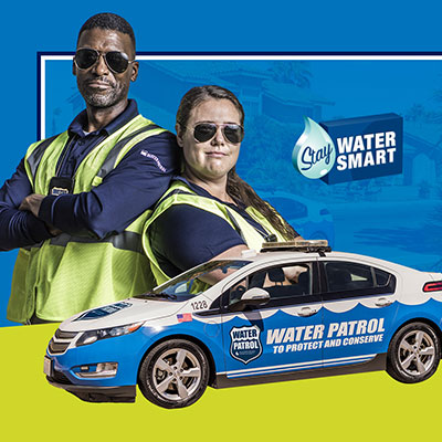 People in reflective vests stand in front of water patrol car