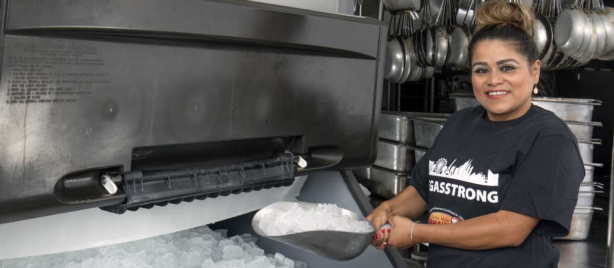 Employee from Doña Maria Tamales scoops ice from a water efficient ice machine
