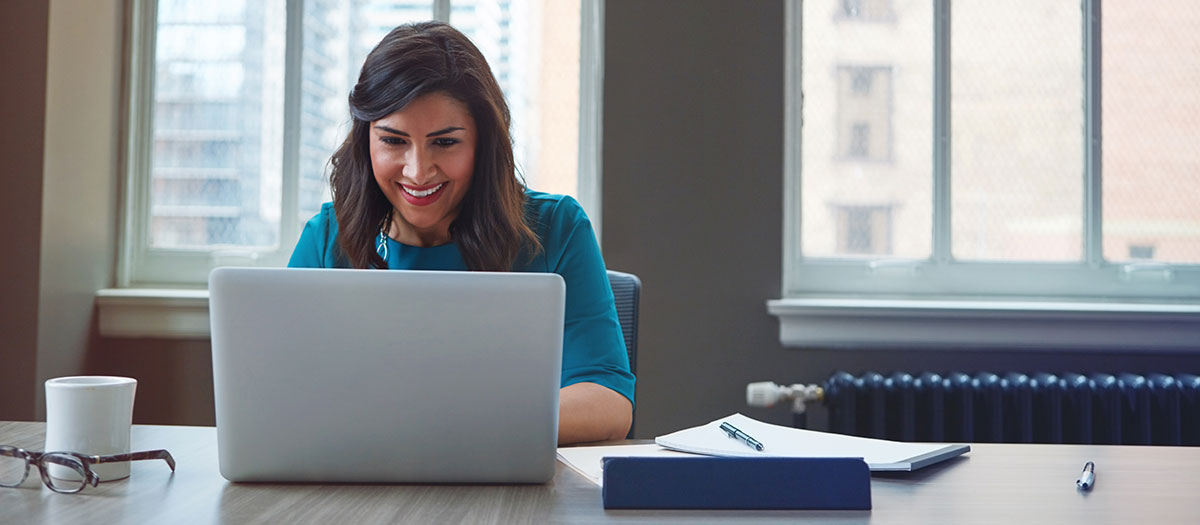 Woman using laptop, smiling