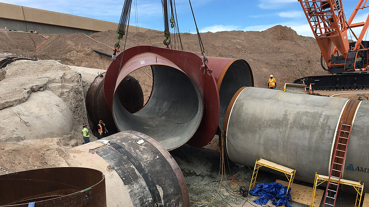 A wye connector is lowered into place at the construction site of the low lake level pumping station.